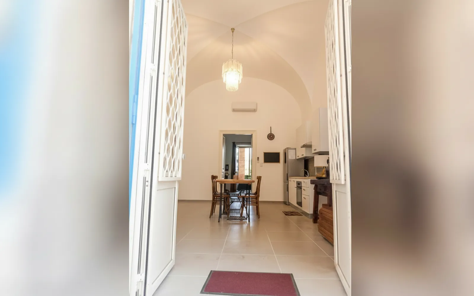 Il tavolo da pranzo in legno visto dalla porta, sotto il soffitto a volta
